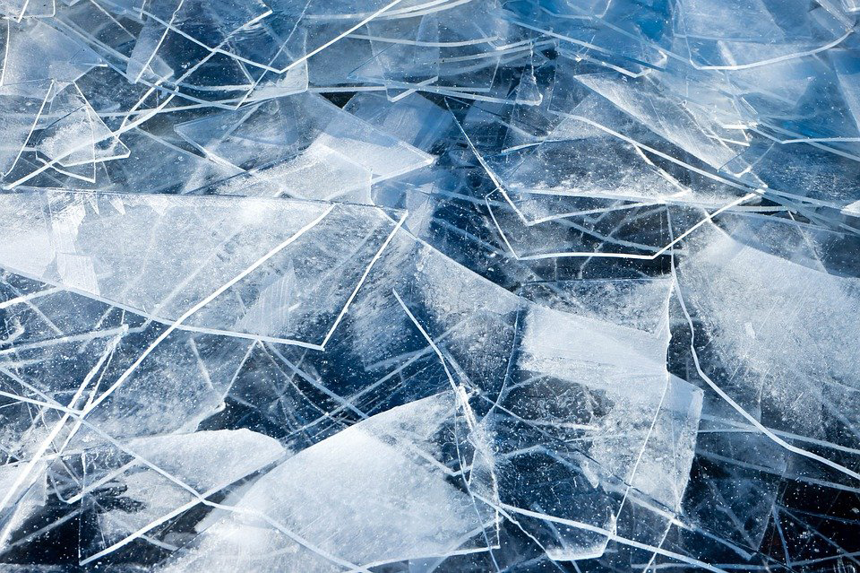  Detail photo of a pile of broken ice sheets that look like broken glass.