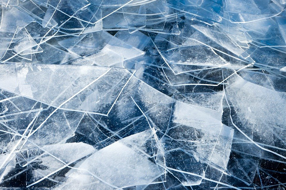 Detail photo of a pile of broken ice sheets that look like broken glass.